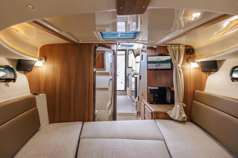 Slide: The Image of 2026 Ranger Tugs R-27 interior with cozy cabin, wood accents, and modern amenities. - 28