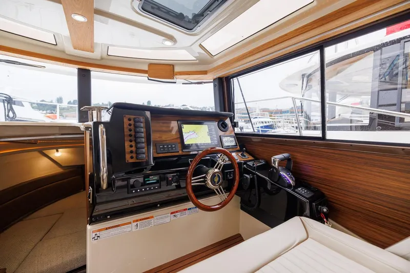 Slide: The Image of Interior of 2026 Ranger Tugs R-27 boat, featuring modern navigation controls and wooden accents. - 29