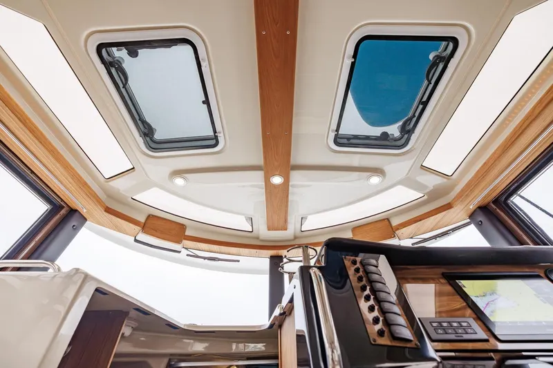 Slide: The Image of Interior view of 2026 Ranger Tugs R-27, featuring skylights and modern navigation controls. - 30