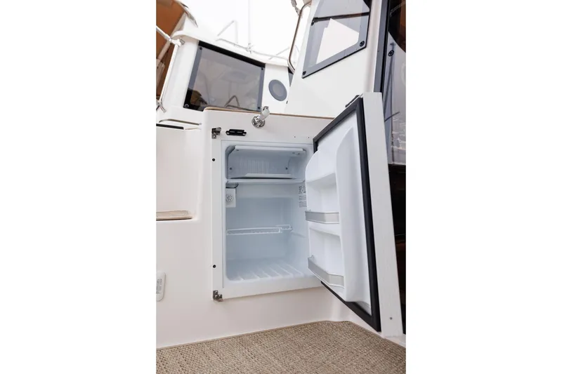 Slide: The Image of Open refrigerator on 2026 Ranger Tugs R-27 boat, showcasing interior storage space. - 31