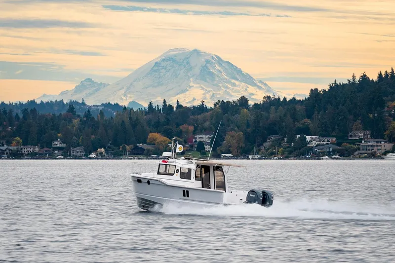 Slide: The Image of 2026 Ranger Tugs R-27 cruising on a lake with a mountain backdrop. - 33