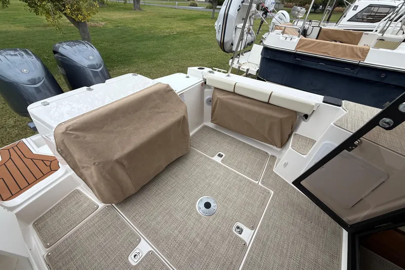 Slide: The Image of 2026 Ranger Tugs R-27 boat cruising on open water with dual outboard engines. - 5