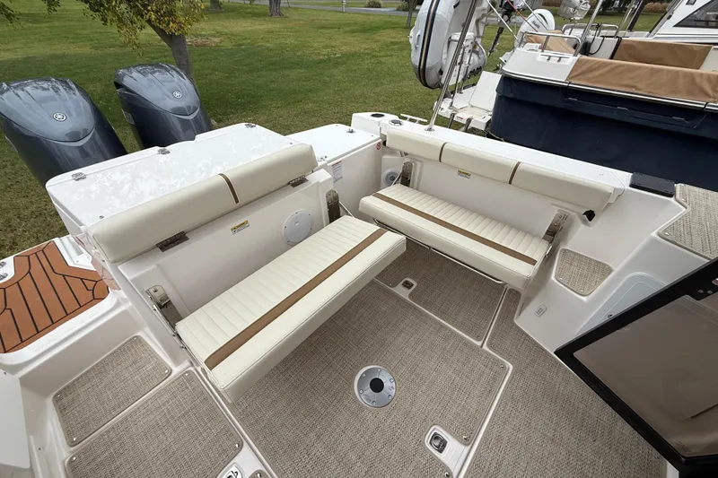 Slide: The Image of 2026 Ranger Tugs R-27 cruising on open water, featuring dual outboard motors. - 6