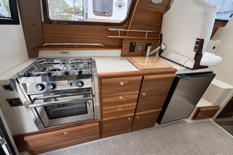 Slide: The Image of 2026 Ranger Tugs R-27 cruising on a scenic lake with city skyline in background. - 9