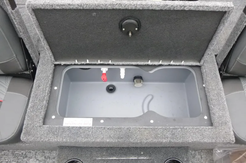 Slide: The Image of 2026 Tracker Targa V-18 Combo boat storage compartment with open lid, gray interior. - 15