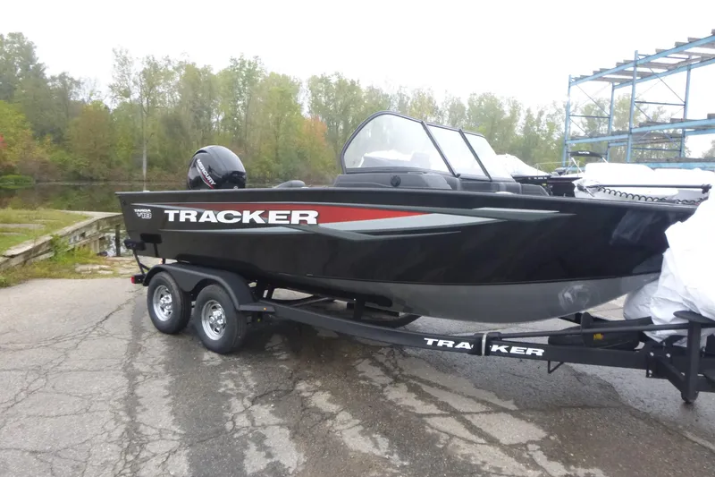 Slide: The Image of 2026 Tracker Targa V-18 Combo boat on trailer, parked near a lake. - 3