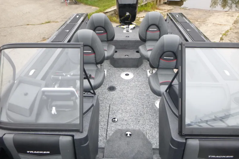 Slide: The Image of 2026 Tracker Targa V-18 Combo boat interior with seating and windshield, docked near water. - 6