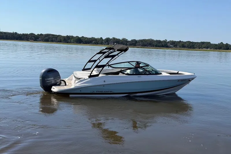 The Image of 2023 Regal 21 OBX boat cruising on calm water with Yamaha outboard motor. - 0