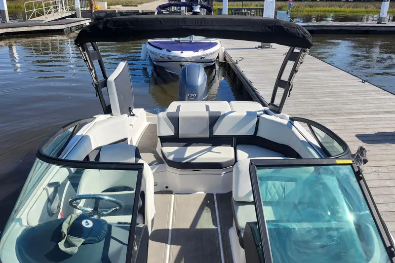 Slide: The Image of 2023 Regal 21 OBX boat docked, featuring spacious seating and sleek design. - 11