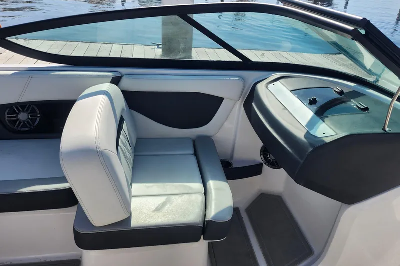 Slide: The Image of 2023 Regal 21 OBX boat interior with seating and dashboard, dockside view. - 16