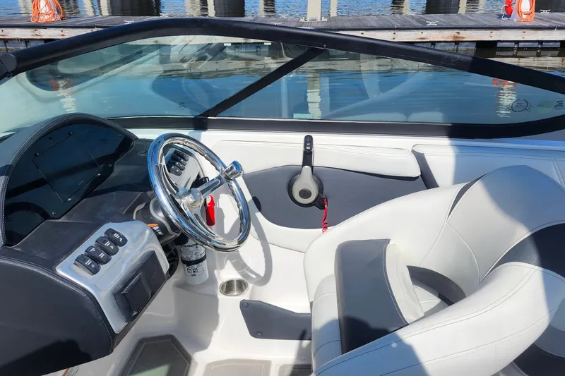 Slide: The Image of 2023 Regal 21 OBX boat interior with steering wheel and dashboard, dockside view. - 18