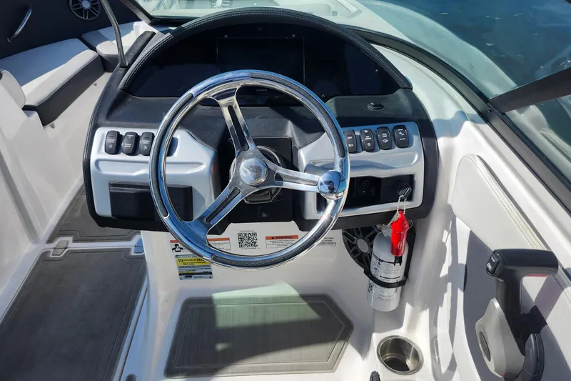 Slide: The Image of 2023 Regal 21 OBX boat dashboard with steering wheel and control panel. - 19