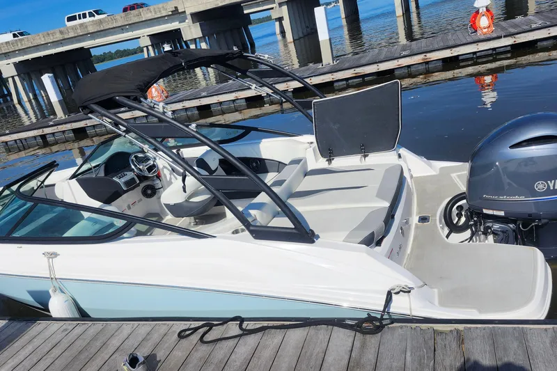 Slide: The Image of 2023 Regal 21 OBX boat docked by a pier, featuring sleek design and Yamaha outboard motor. - 26