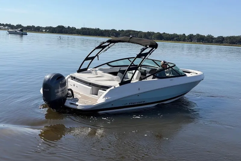 Slide: The Image of 2023 Regal 21 OBX boat on calm water, featuring a Yamaha outboard motor. - 32