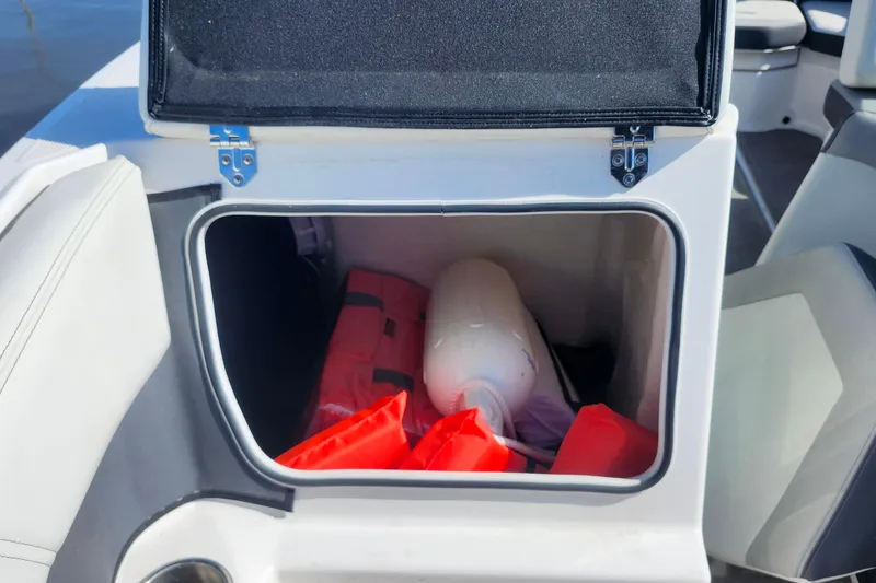 Slide: The Image of 2023 Regal 21 OBX boat storage compartment with life jackets and fender. - 8