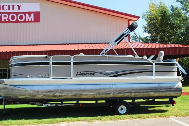 Slide: The Image of 2012 Premier 221 Gemini pontoon boat on trailer, parked outside showroom. - 1