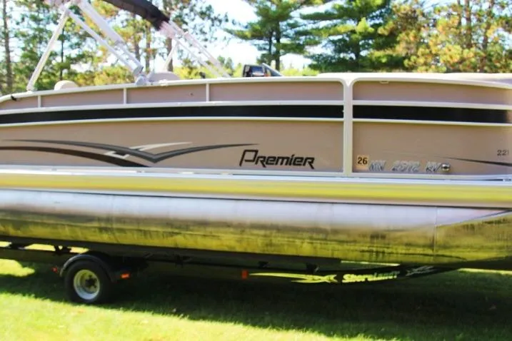 Slide: The Image of 2012 Premier 221 Gemini pontoon boat on trailer, parked on grass with trees in background. - 3