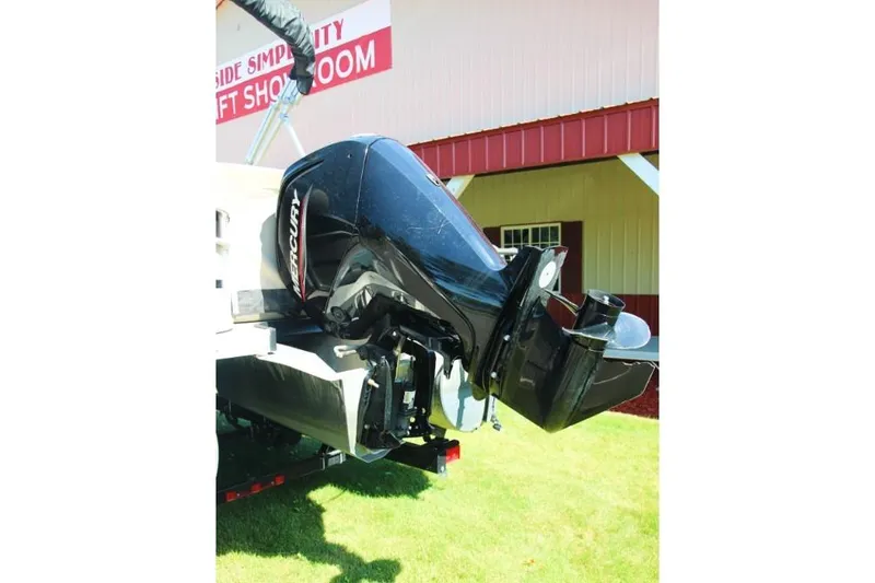 Slide: The Image of 2012 Premier 221 Gemini boat with Mercury outboard motor displayed outside showroom. - 4
