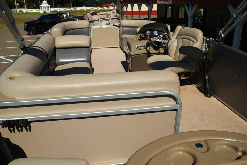 Slide: The Image of 2012 Premier 221 Gemini pontoon boat interior with beige seating and steering console. - 6