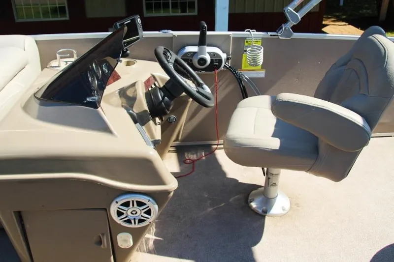 Slide: The Image of Captain's chair and helm of 2012 Premier 221 Gemini boat, featuring steering wheel and controls. - 9