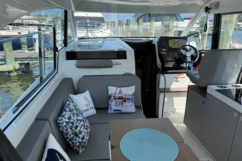 Slide: The Image of Interior of 2024 Beneteau Antares 11, featuring modern seating and helm, docked at marina. - 17