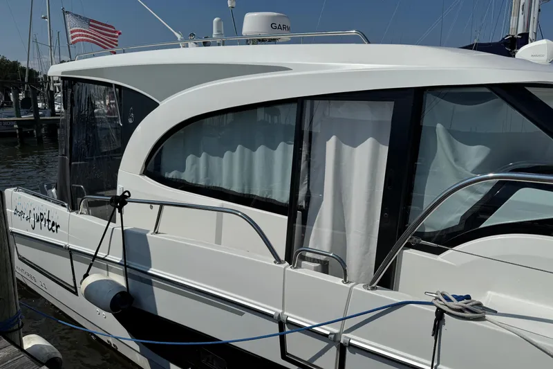 Slide: The Image of 2024 Beneteau Antares 11 docked, featuring sleek design and American flag in background. - 2