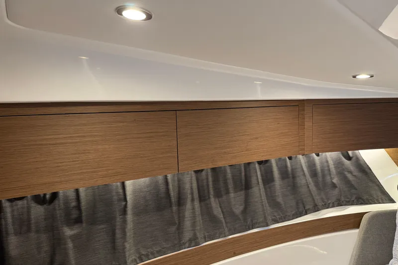 Slide: The Image of 2024 Beneteau Antares 11 interior with wooden cabinets and modern lighting. - 22