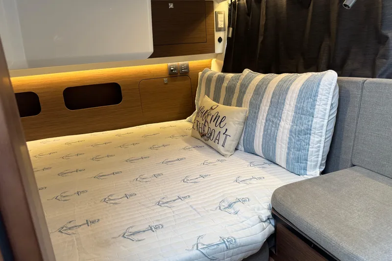 Slide: The Image of 2024 Beneteau Antares 11 cabin interior with nautical-themed bedding and cozy decor. - 27