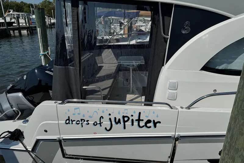 Slide: The Image of 2024 Beneteau Antares 11 boat docked, featuring "drops of jupiter" text on the stern. - 4