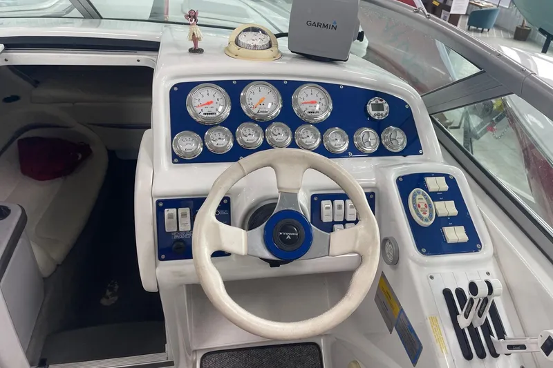 Slide: The Image of 2005 Formula 292 FASTech boat dashboard with steering wheel, gauges, and Garmin device. - 8