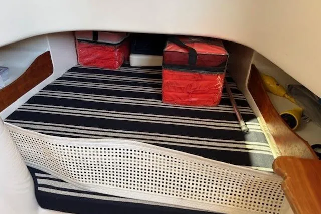 Slide: The Image of 2013 Grady-White Canyon 336 cabin interior with striped cushions and storage bags. - 21