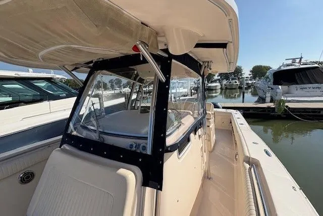 Slide: The Image of 2013 Grady-White Canyon 336 boat docked at marina, featuring spacious deck and canopy. - 24