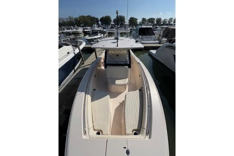 Slide: The Image of 2013 Grady-White Canyon 336 boat docked at marina, showcasing spacious deck and seating. - 27