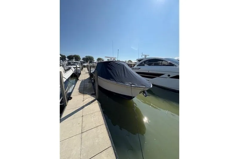 Slide: The Image of 2013 Grady-White Canyon 336 boat covered at marina dock under clear sky. - 3
