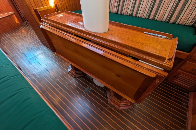 Slide: The Image of Interior of 1983 Robert Perry 41 yacht with wooden table and striped seating. - 12