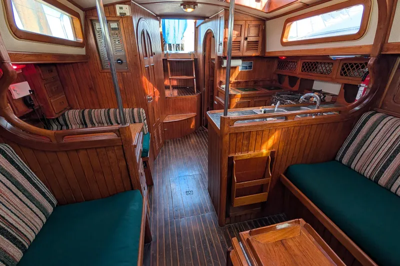 Slide: The Image of Interior of a 1983 Robert Perry 41 sailboat with wooden furnishings and cozy seating. - 13