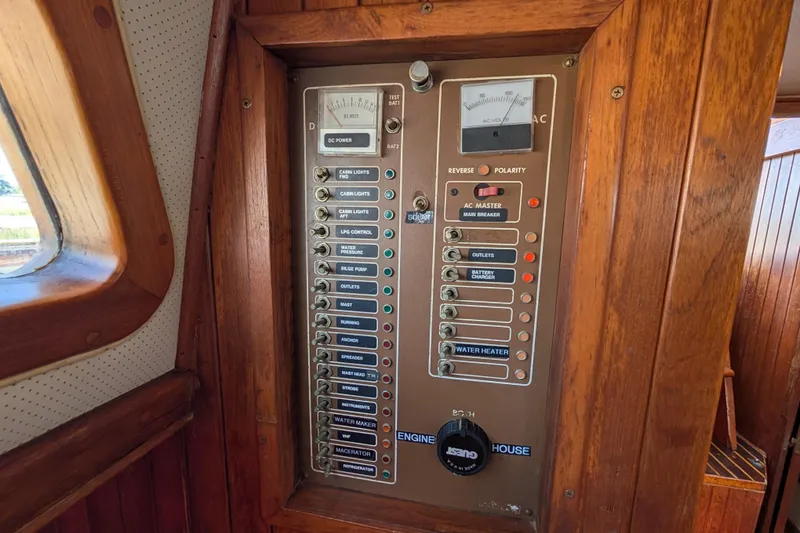 Slide: The Image of Electrical control panel on a 1983 Robert Perry 41 sailboat, featuring various switches and gauges. - 16