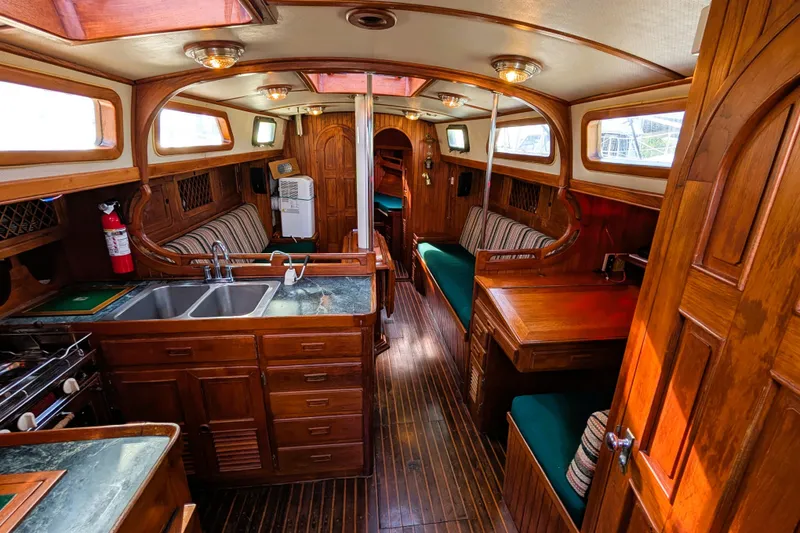 Slide: The Image of Interior of 1983 Robert Perry 41 sailboat with wooden furnishings and cozy seating. - 2