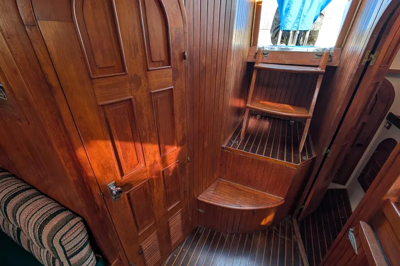 Slide: The Image of Interior of 1983 Robert Perry 41 sailboat with wooden paneling and steps. - 27