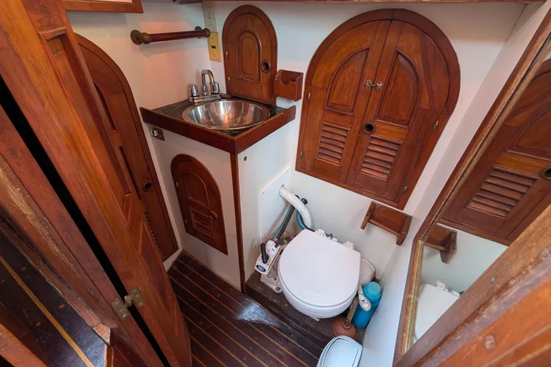 Slide: The Image of Vintage 1983 Robert Perry 41 yacht bathroom with wooden cabinetry and compact design. - 28