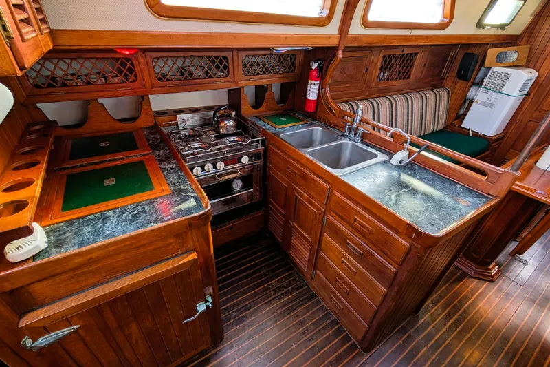Slide: The Image of Vintage 1983 Perry 41 yacht kitchen with wood cabinetry, stove, and dual sink. - 3