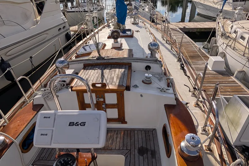 Slide: The Image of 1983 Robert Perry 41 sailboat docked, featuring wooden deck and B&G navigation equipment. - 31