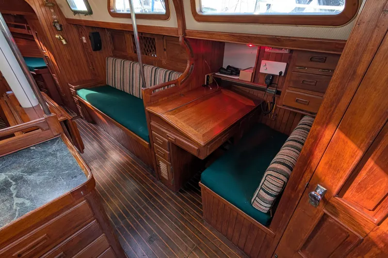 Slide: The Image of Interior of 1983 Robert Perry 41 sailboat with wooden furnishings and green cushions. - 4