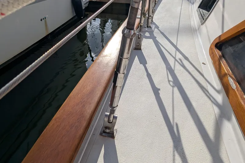 Slide: The Image of Deck view of a 1983 Robert Perry 41 sailboat, featuring wooden railings and metal rigging. - 40