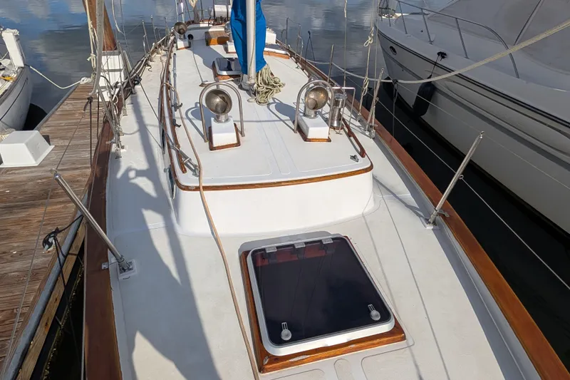 Slide: The Image of Sailboat deck of 1983 Robert Perry 41, docked with visible hatch and rigging. - 43