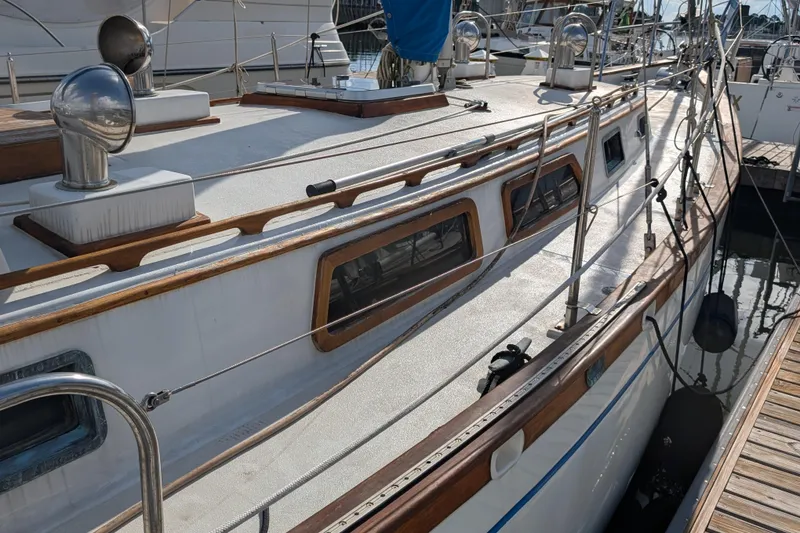 Slide: The Image of 1983 Robert Perry 41 sailboat docked, showcasing deck and cabin details. - 44