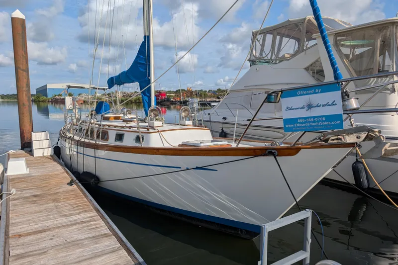 Slide: The Image of 1983 Robert Perry 41 sailboat docked at marina, clear sky, calm water. - 52