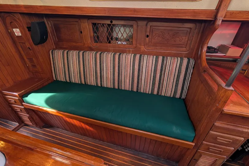 Slide: The Image of Vintage 1983 Robert Perry 41 sailboat interior with wooden cabinetry and striped upholstery. - 6