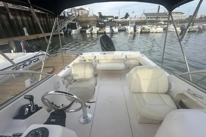 Slide: The Image of 2004 Grady-White Tournament 225 boat interior at marina, featuring seating and steering wheel. - 12