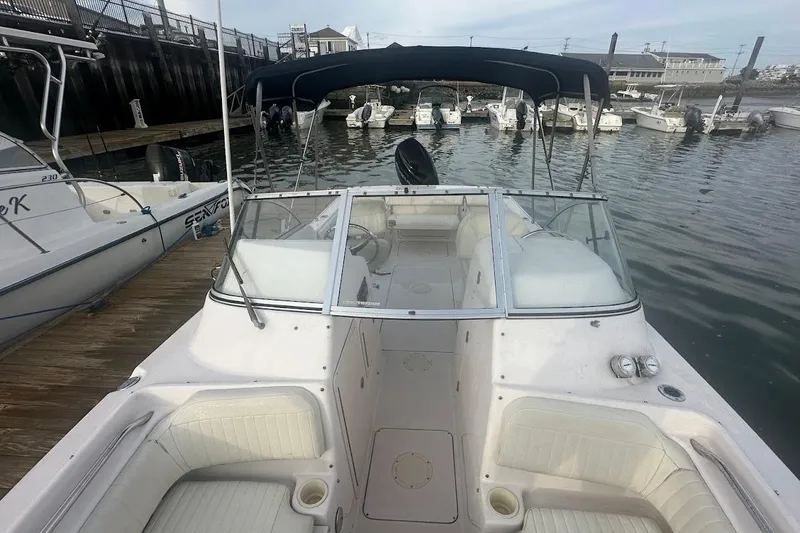 Slide: The Image of 2004 Grady-White Tournament 225 boat docked, featuring spacious seating and canopy. - 14